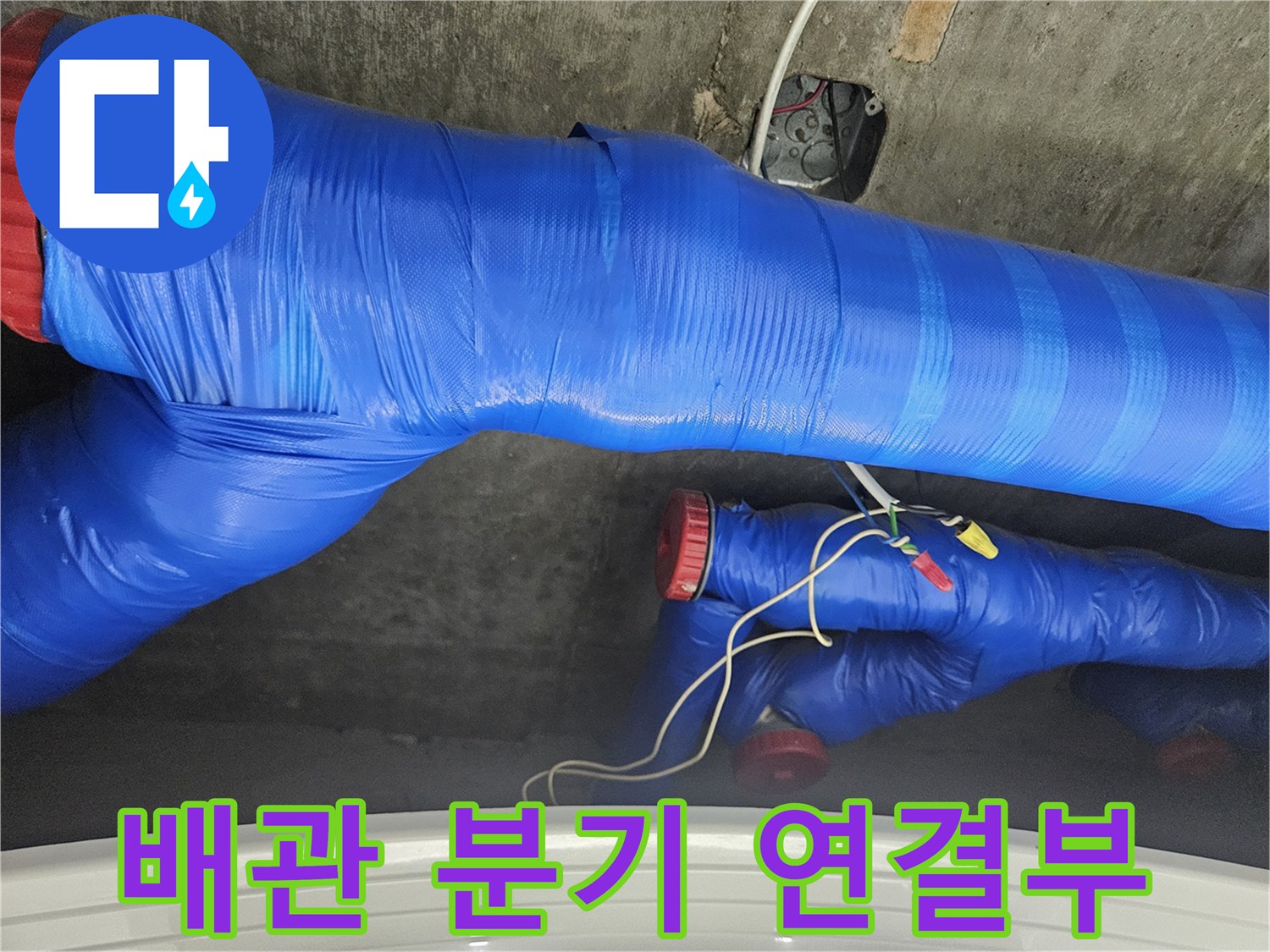 파란색 테이프로 감싸진 배관의 분기 지점