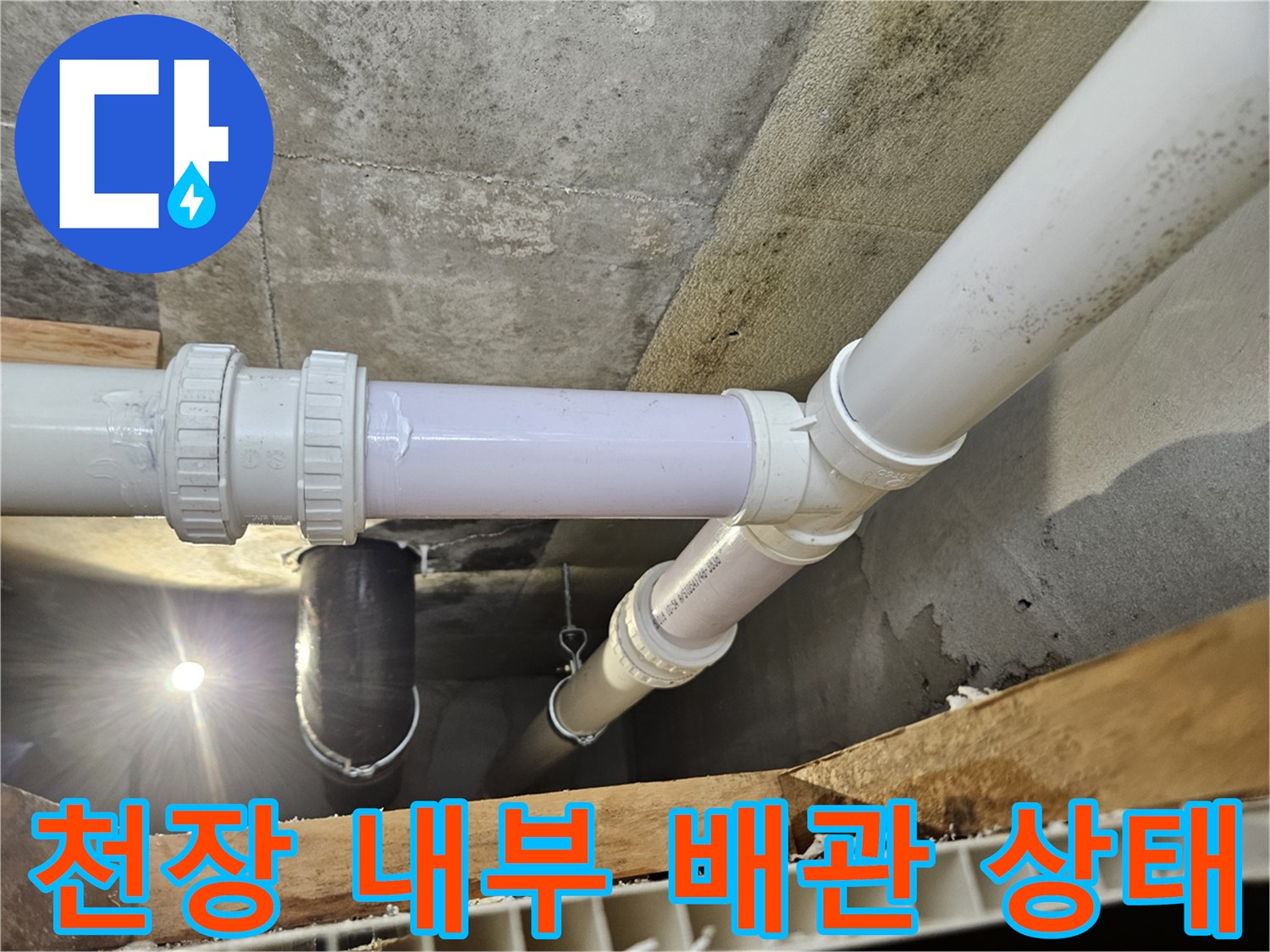 천장 점검구 안쪽의 흰색 하수 배관 구조물 촬영