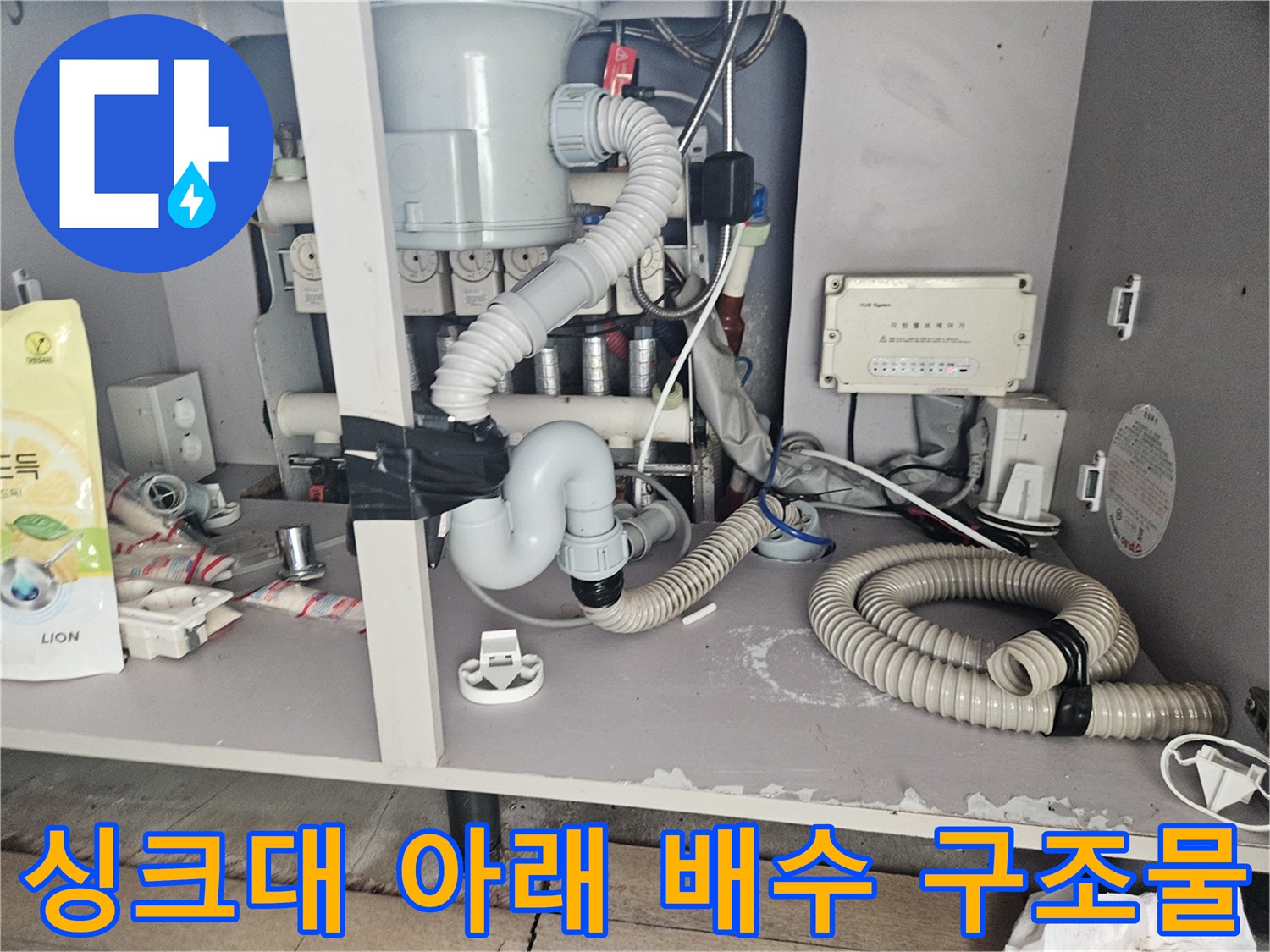 싱크대 하부의 연결된 주름 호스와 배수 장치들