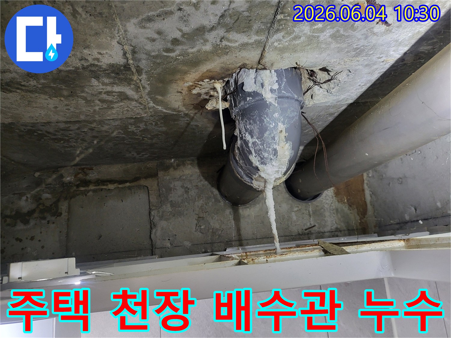 천장 콘크리트와 배수관 연결 부위에서-물이 새어 하얀 석회질이 길게 형성된 모습