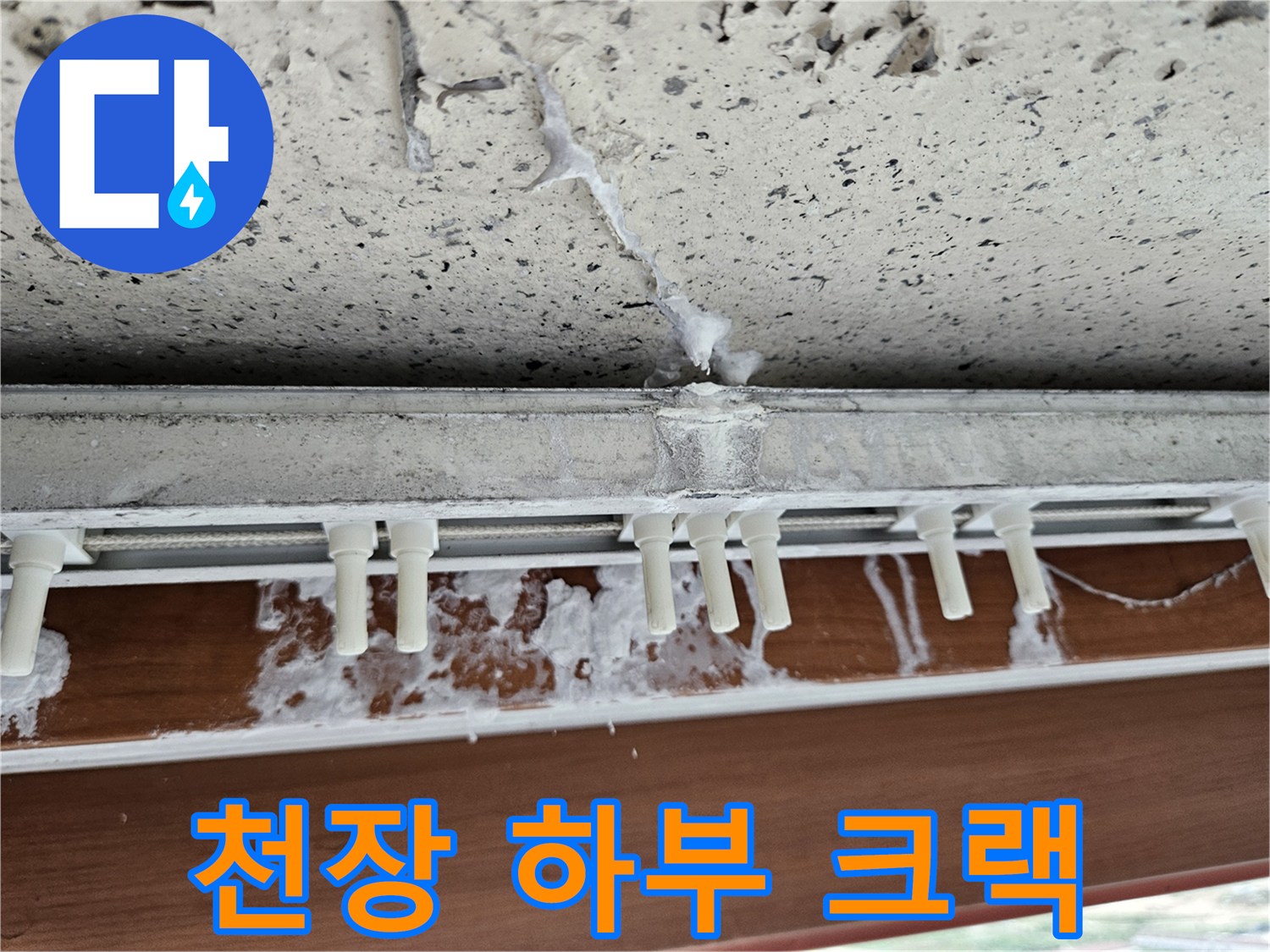 창틀 아래 천장 마감재의 갈라짐과 젖은 흔적