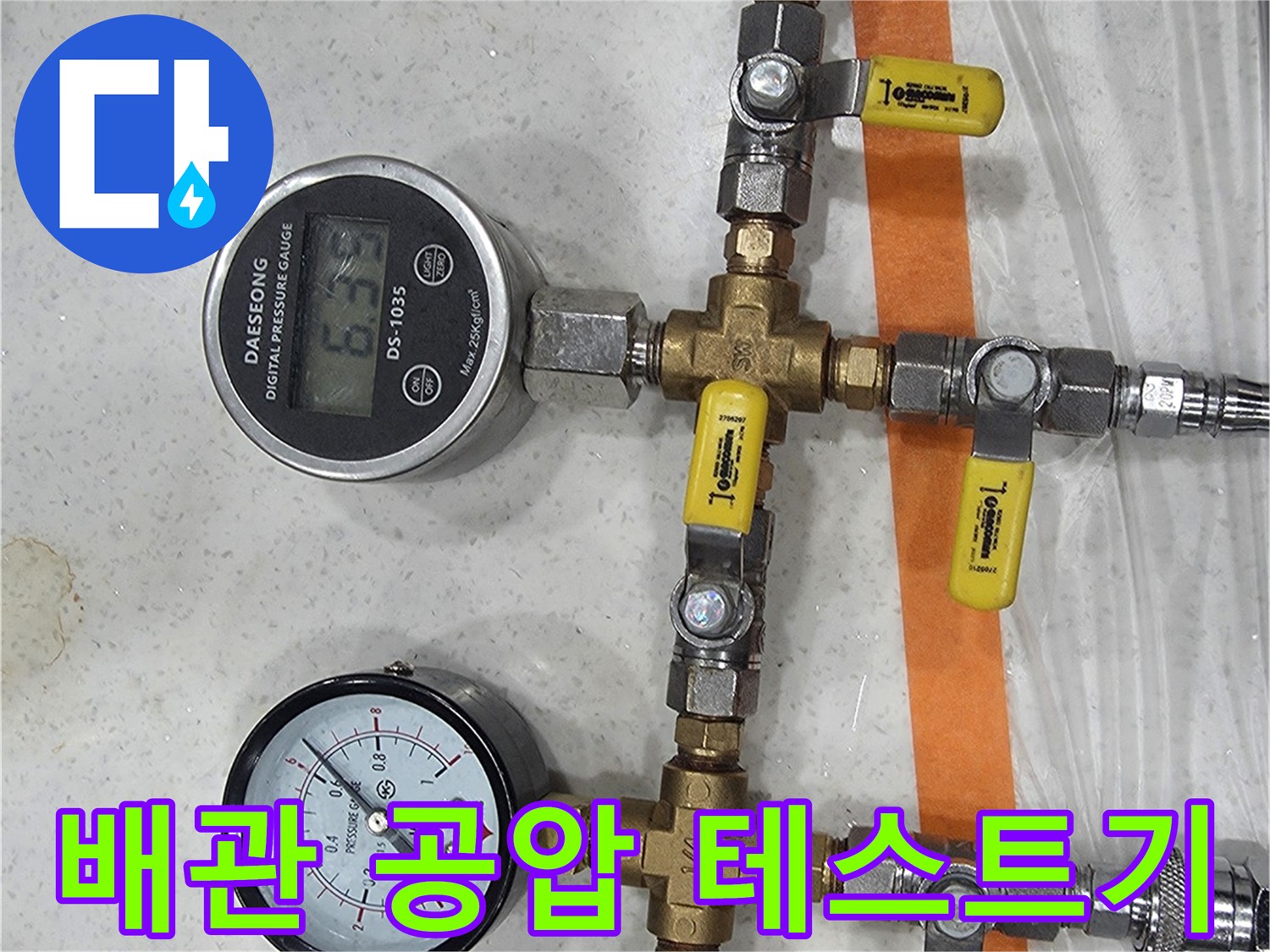배관 연결 부위에 설치된 압력 측정용 밸브와 게이지 장비입니다.