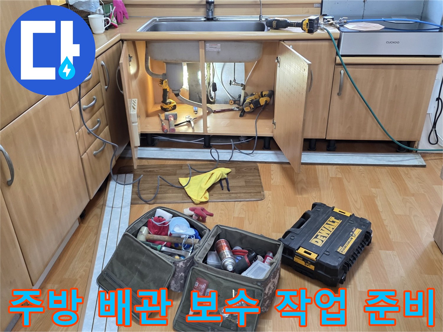 작업을 위해 싱크대 밑 공간에 배치된 각종 수리 도구와 자재