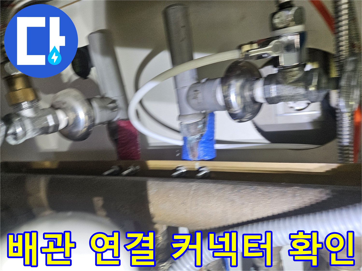 싱크대 하단 분배기 밸브와 연결된 배관 부위의 근접 촬영 사진