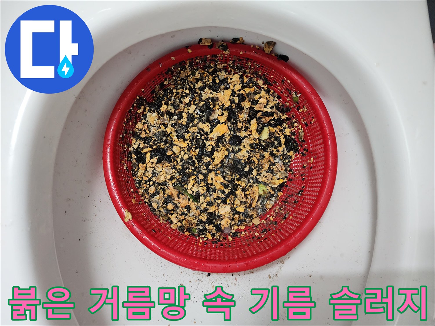 붉은색 거름망에 가득 쌓인 검고 노란 기름 슬러지 덩어리들