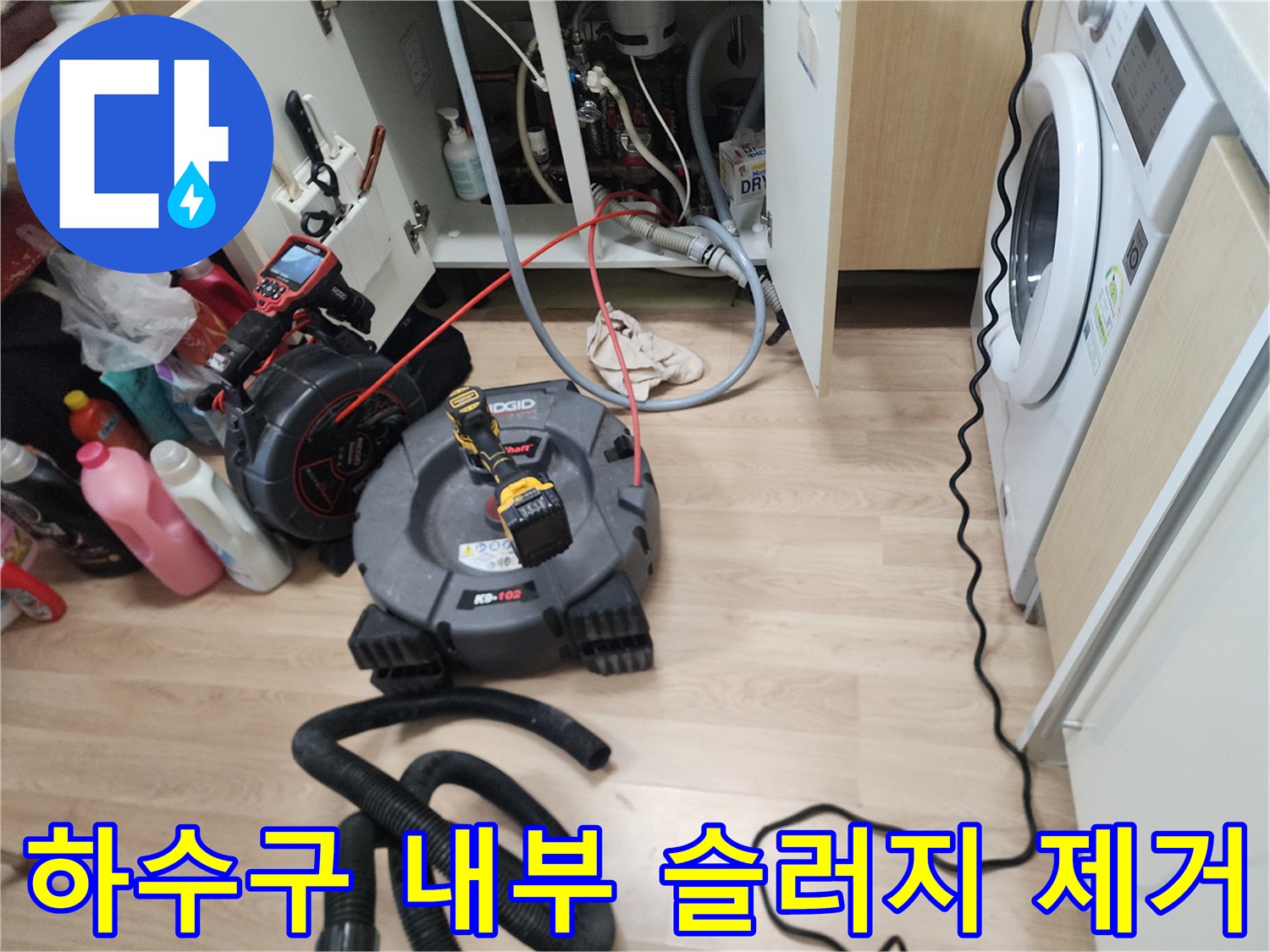 싱크대 아래쪽 배관 클리닝을 위해 가동 중인 전문 장비 세트