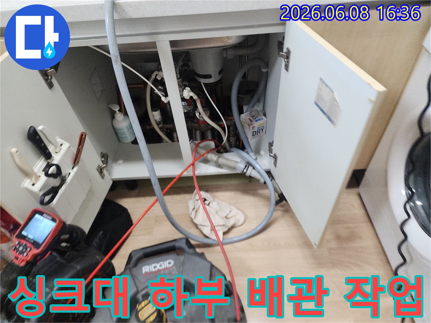 작업을 위해 준비된 싱크대 하단 배관과 전문 장비 케이블