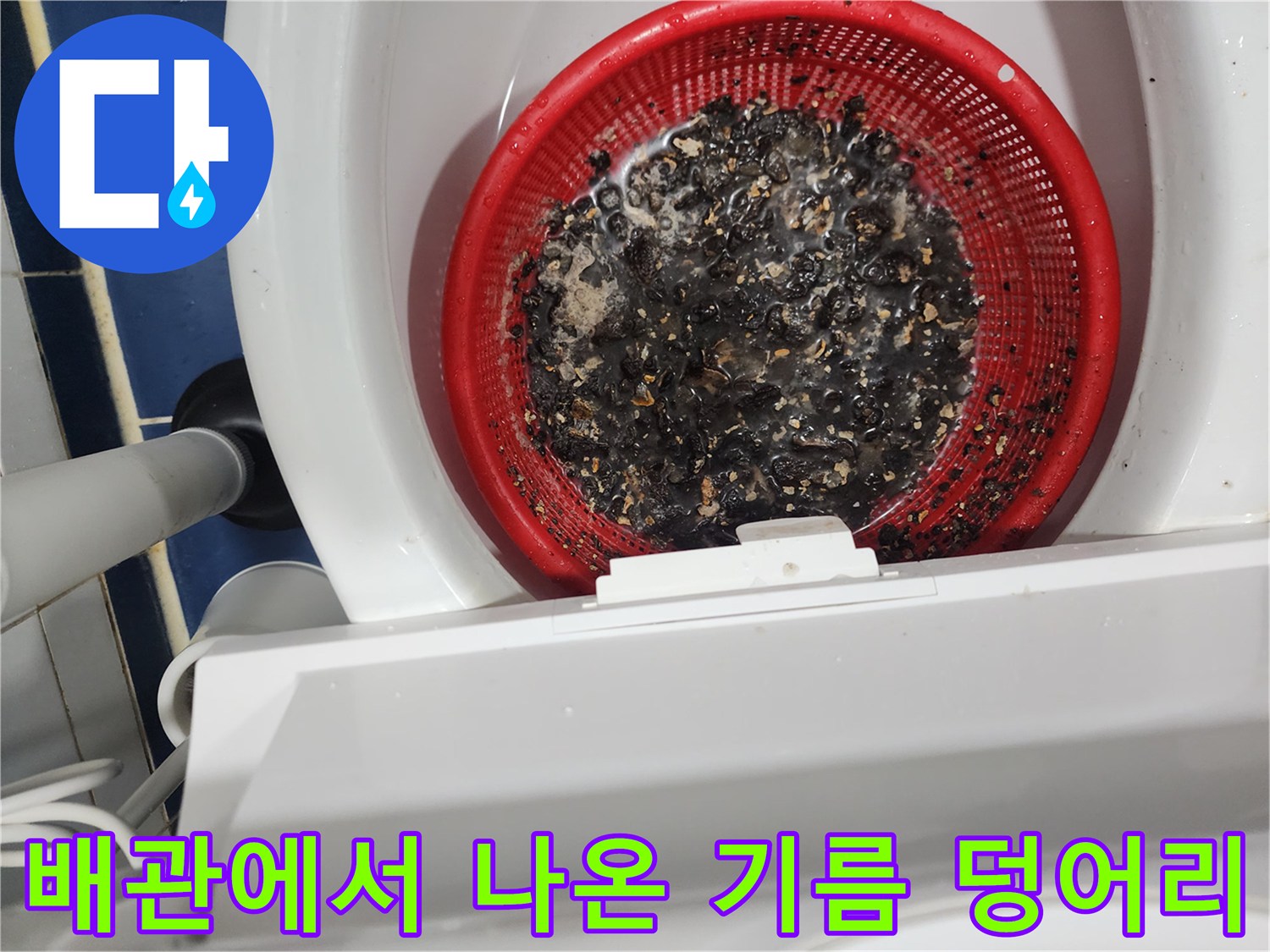 빨간 거름망에 쌓인 검은색 배수관 오염물