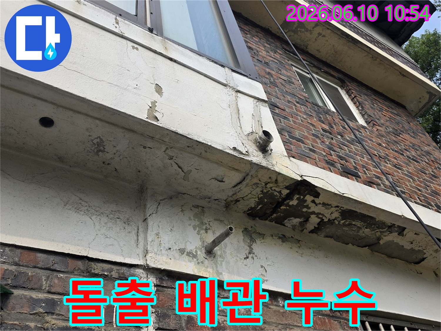 건물-외벽에-돌출된-금속-배관-주변-콘크리트-손상과-누수-징후