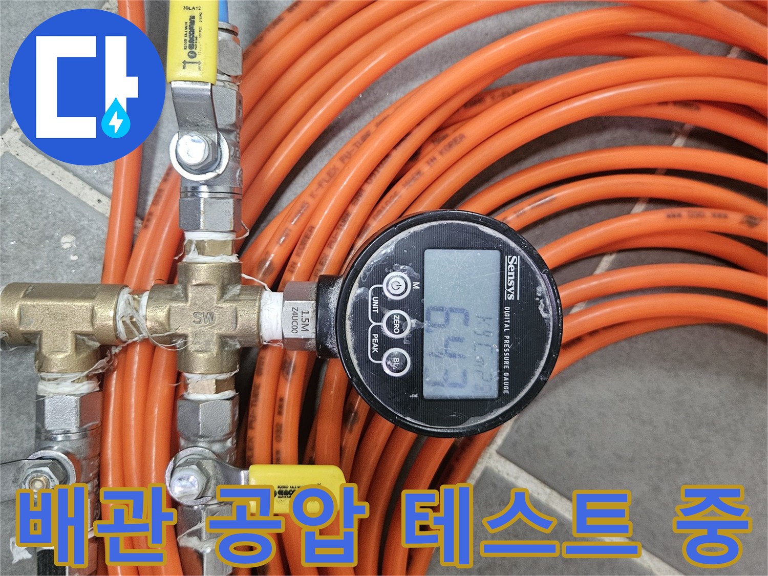 주황색 호스와 연결된 배관용 압력 측정 장비