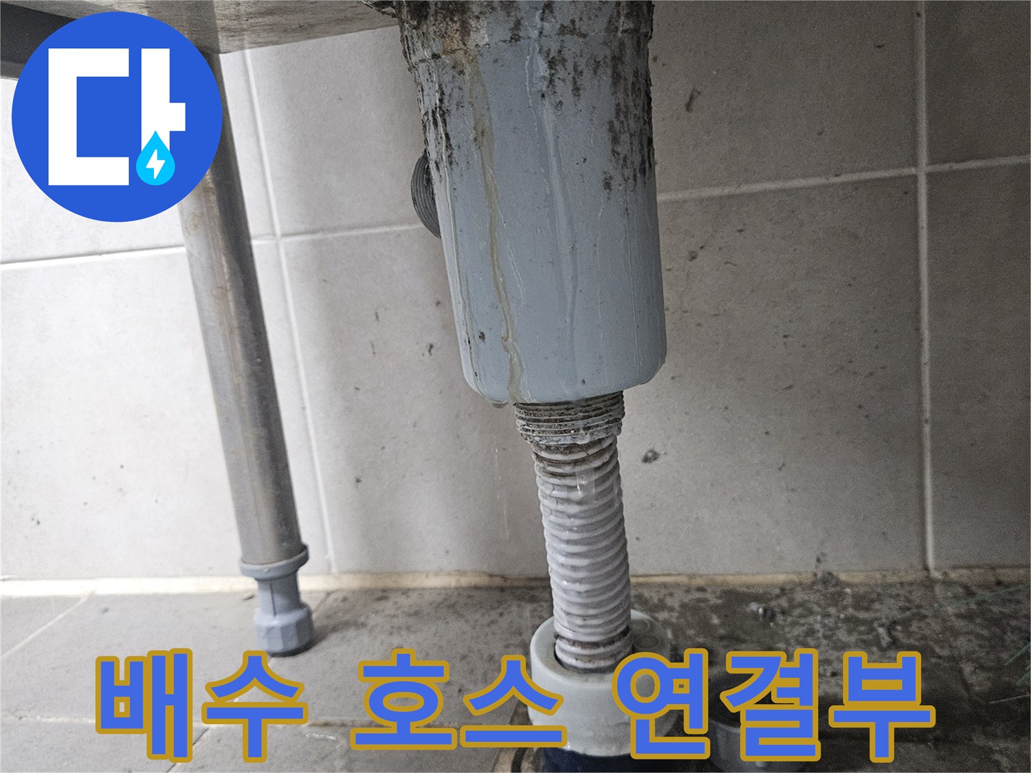 타일-벽면에-연결된-세탁실-배수-호스