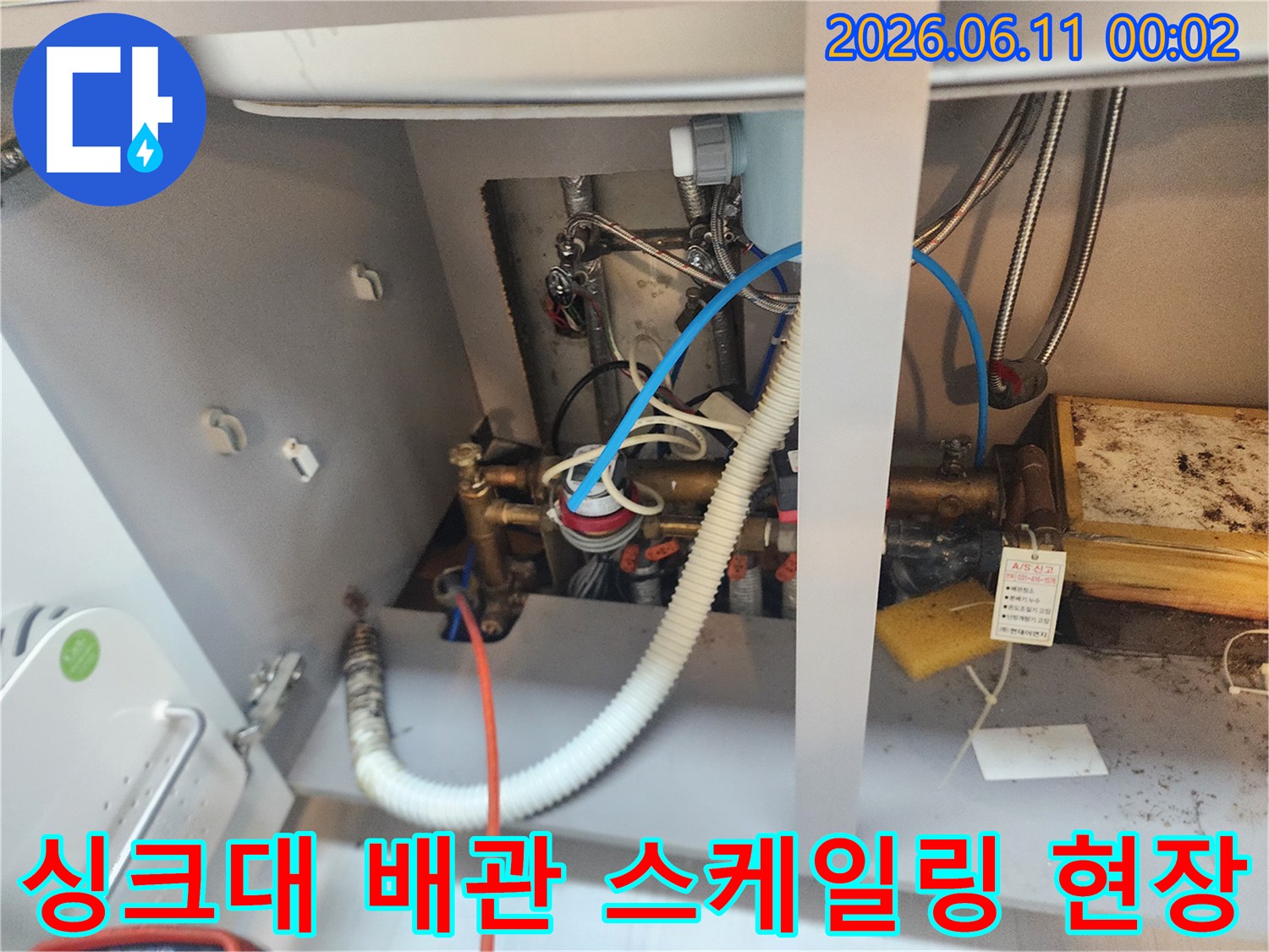 싱크대 하부장의 복잡한 배관 연결 상태와 작업 중인 모습