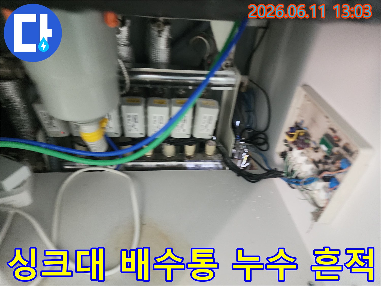 누수로 오염된 싱크대 하부장 바닥과 배관 연결 부위 사진