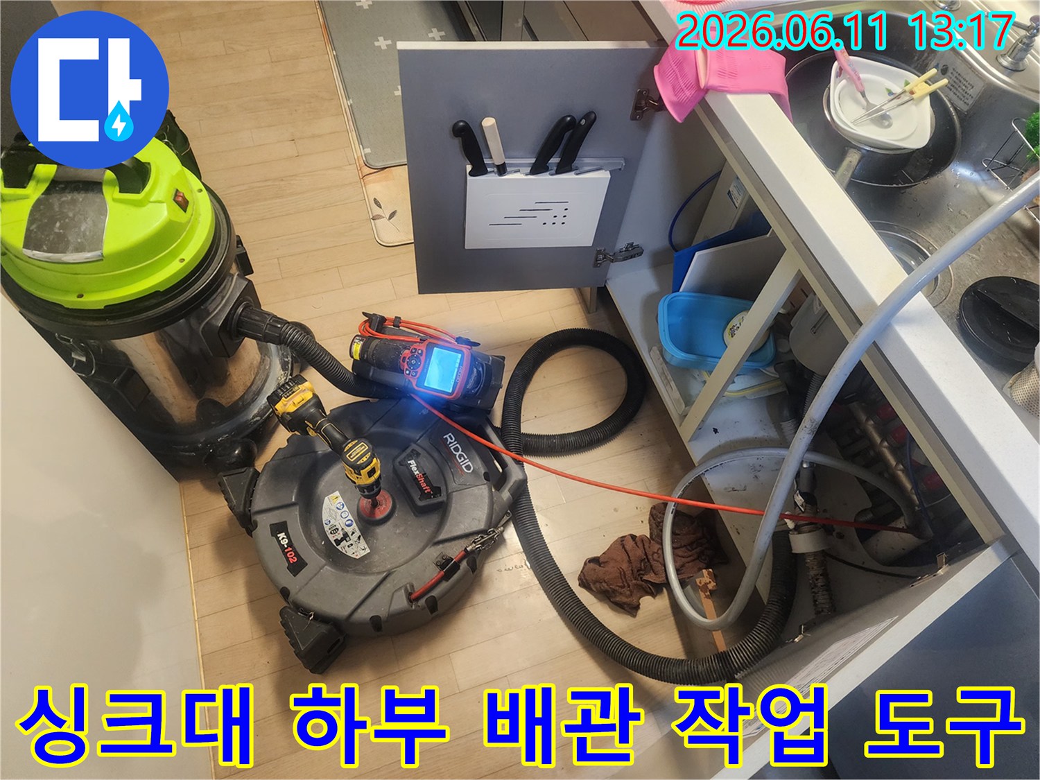 싱크대 하부장 공간에 배치된 배관 스케일링기와 대형 석션기 장비 세트