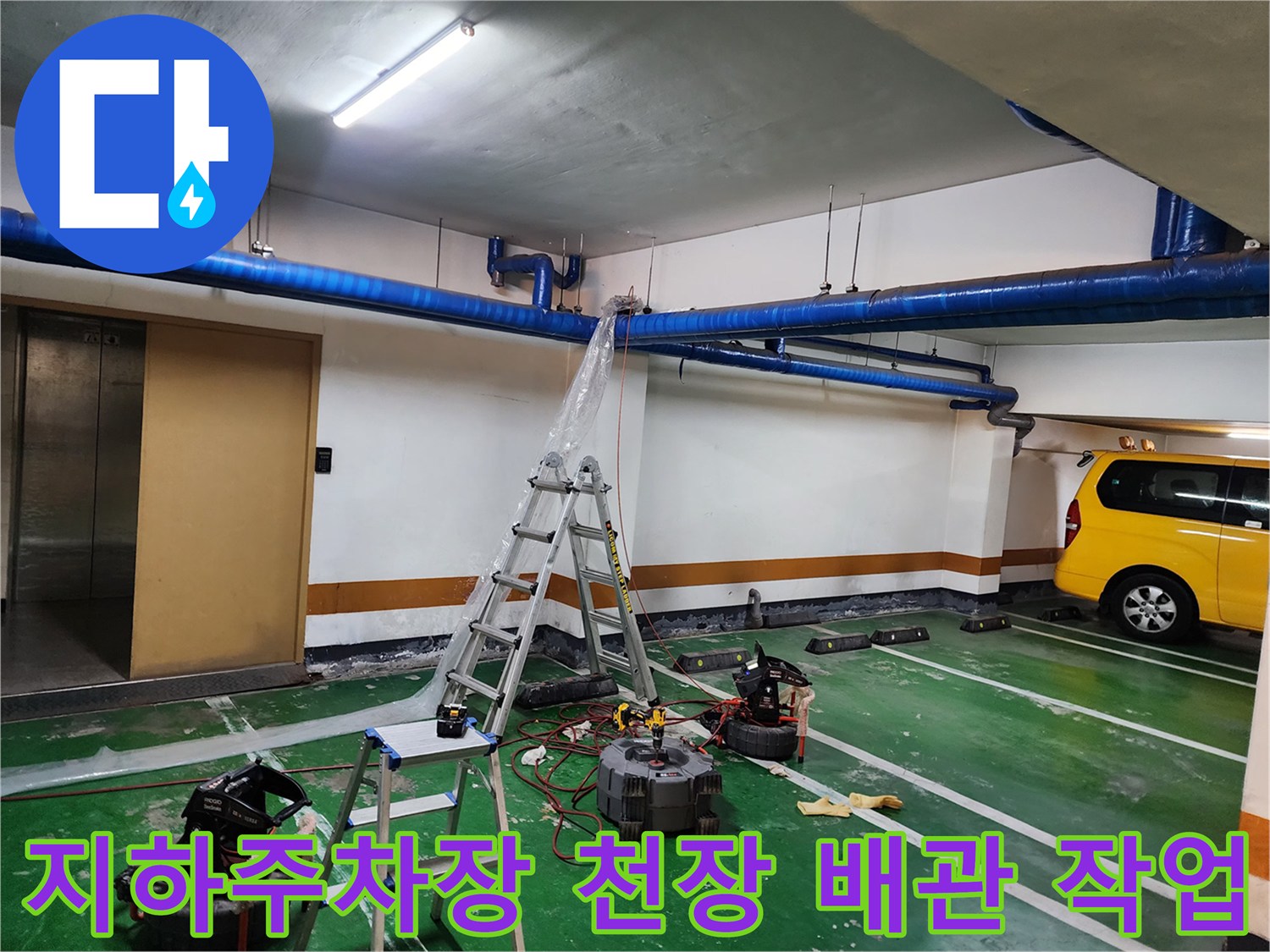 지하주차장-천장에 설치된 파란색 배관과 작업용 사다리 모습