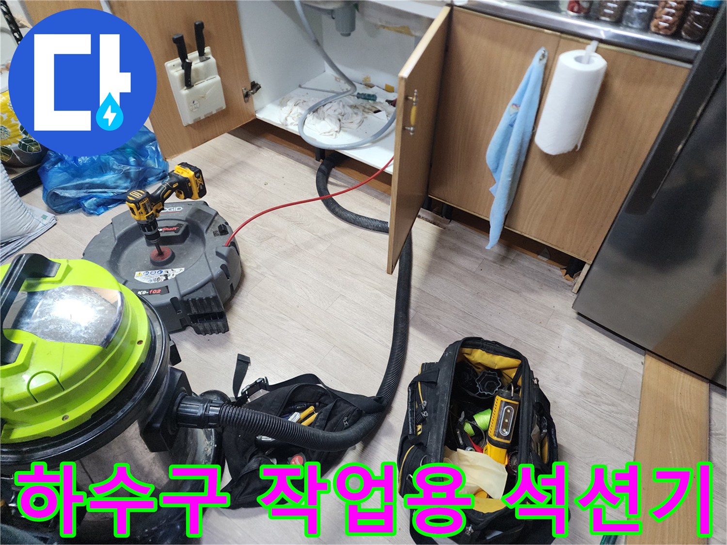 싱크대 아래 공간에 놓인 배관 청소용 석션기와 공구 세트