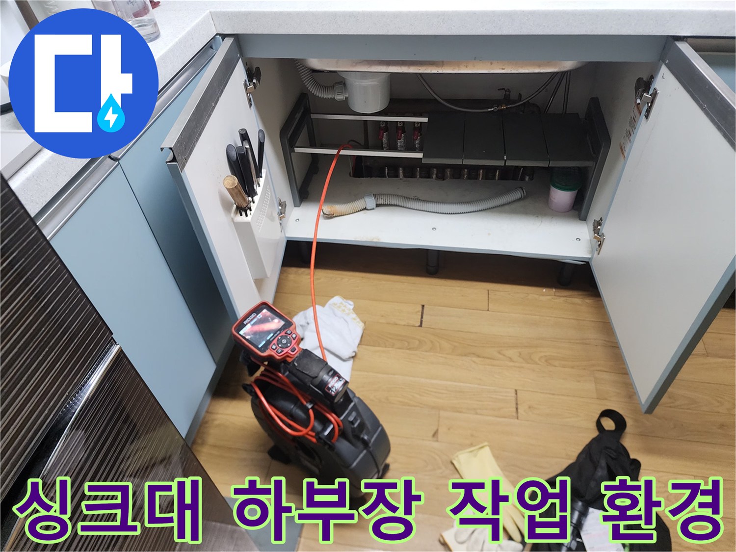 배수관 막힘 해결을 위해 준비된 전문 장비와 싱크대 하부 공간