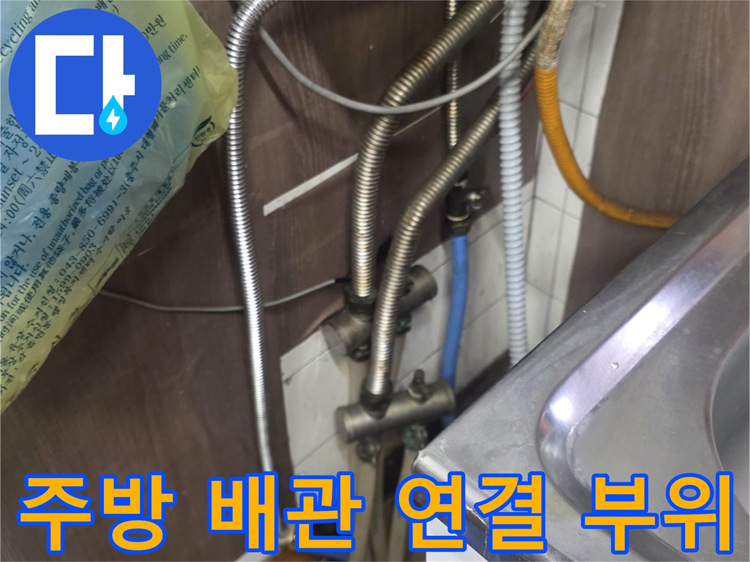 싱크대 아래쪽 금속 재질의 급수 및 온수 배급 배관들