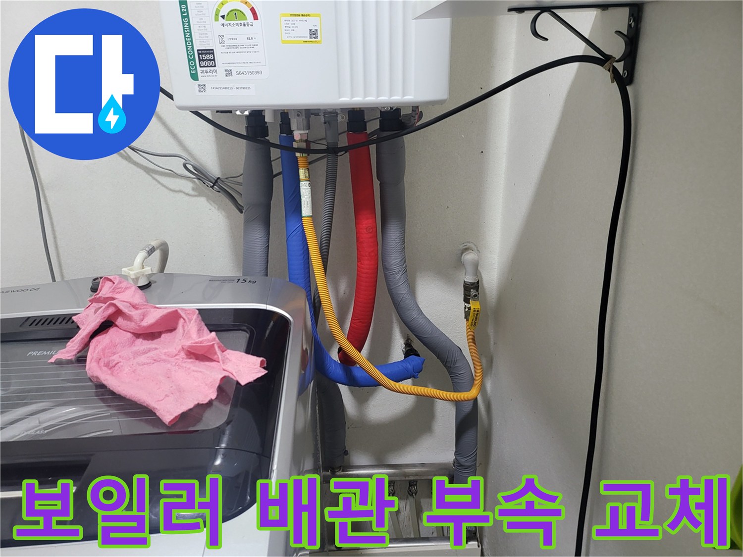 보일러-하단에-연결된-다양한-색상의-배관과-호스들