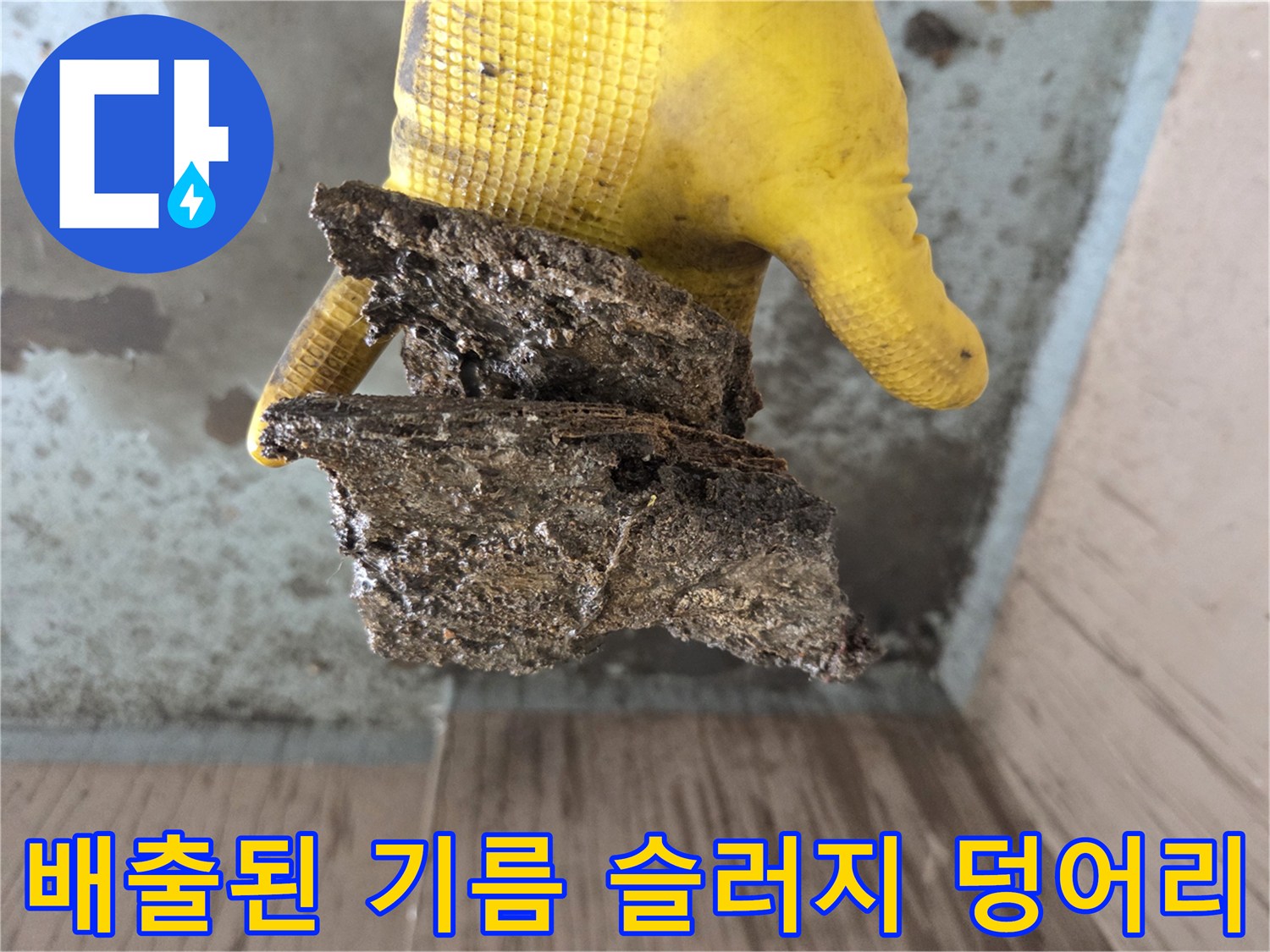 노란 장갑 위에 놓인 거대한 배관 이물질 조각들