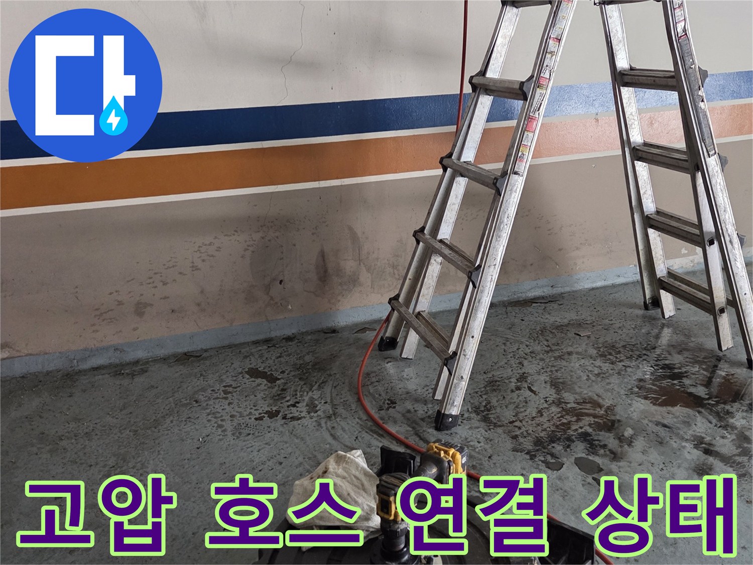 배관 입구에 연결된 붉은색 고압 세척 호스