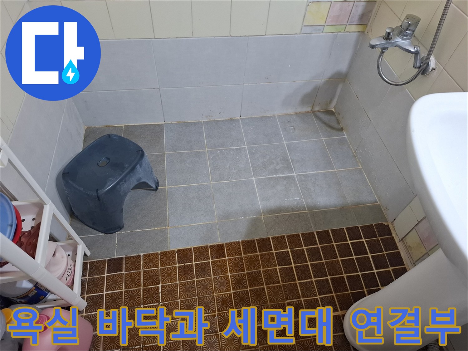 세면대 아래쪽의 노후된 타일 틈새를 보여주는 사진입니다.