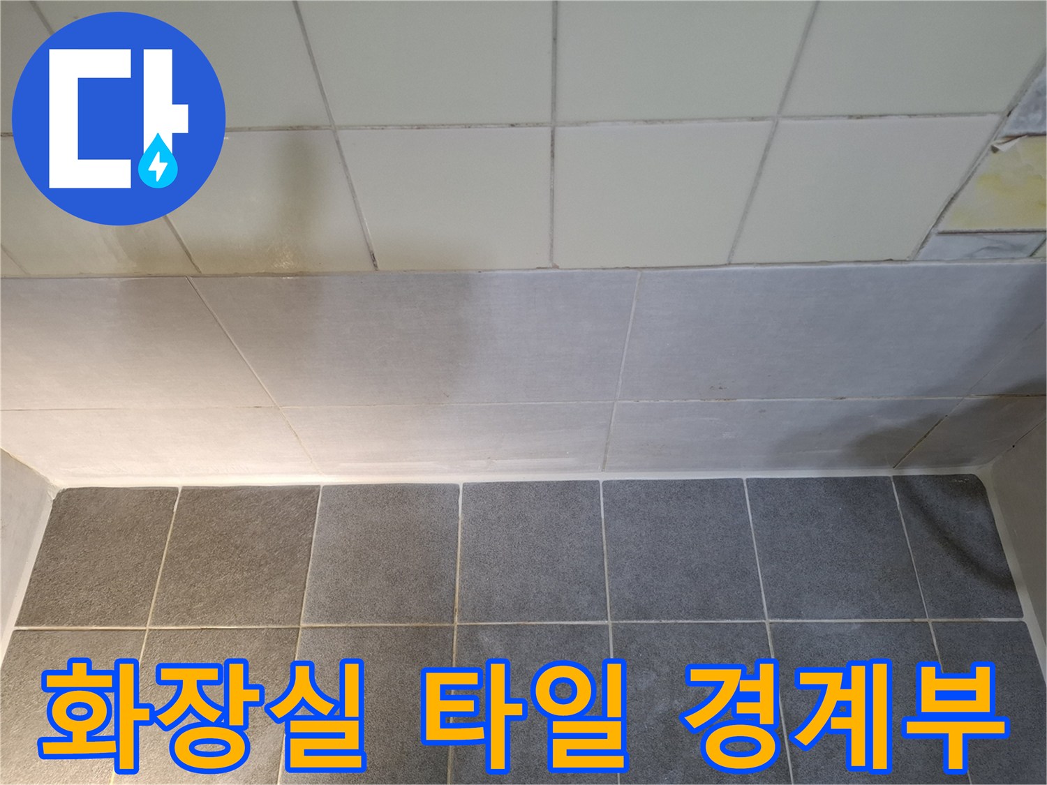 욕실 벽면 하단과 바닥 타일이 만나는 지점의 근접 사진