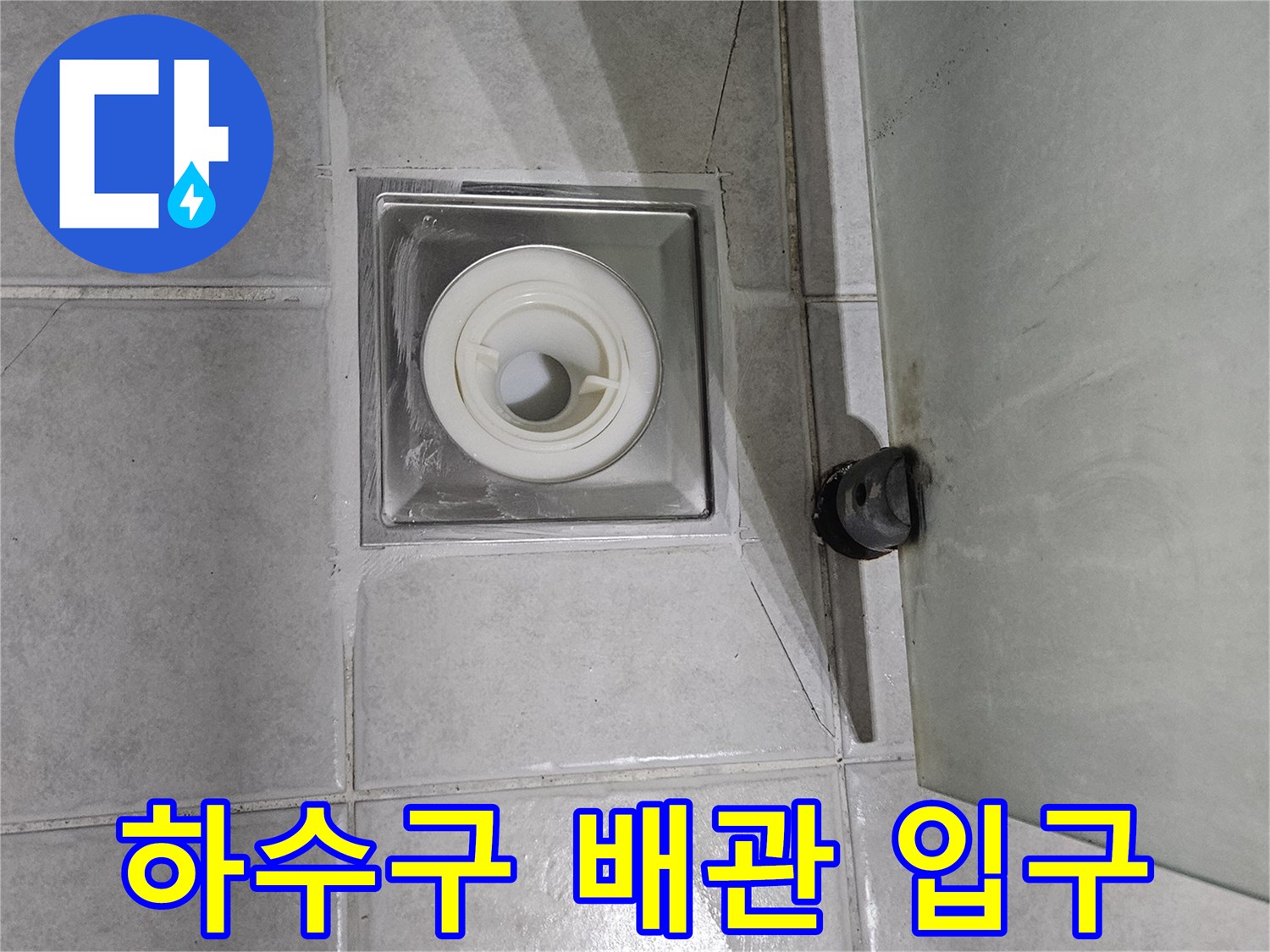 타일 사이 하수구 배관 연결 부위의 노출된 모습