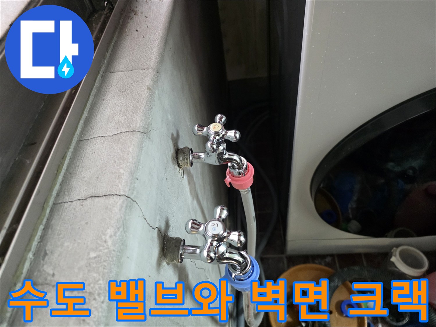 은색 수도꼭지와 연결된 호스 주변의 갈라진 벽면 모습