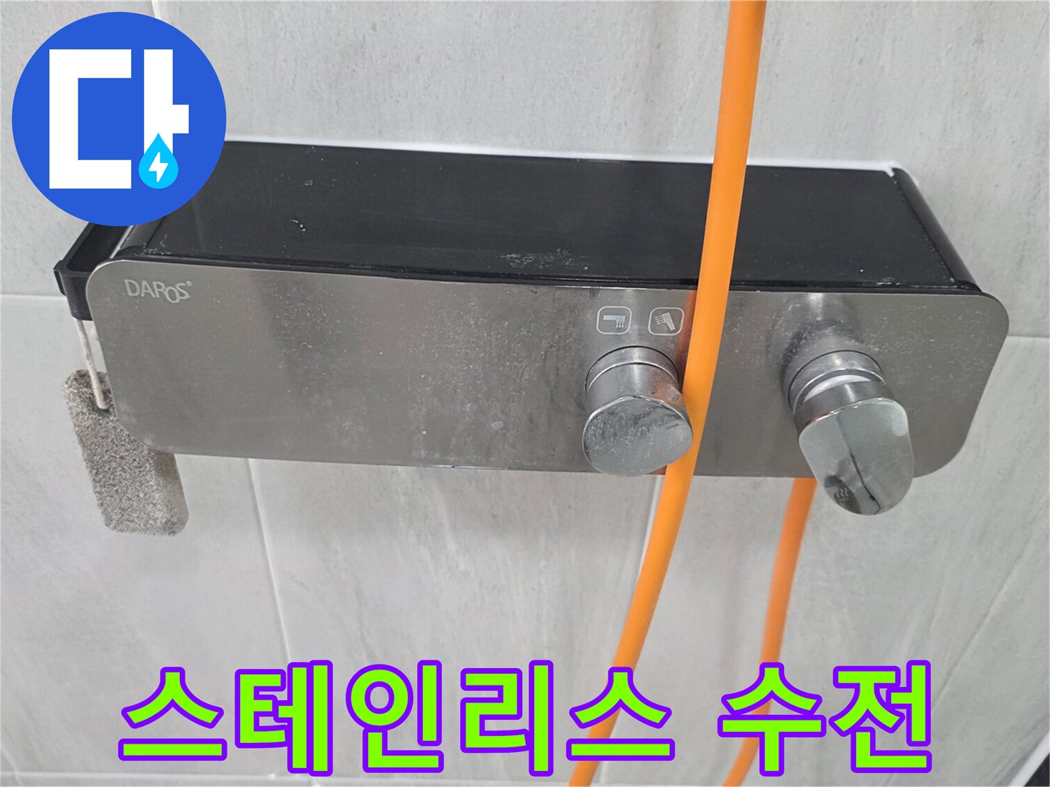 금속 재질의 수전과 연결된 주황색 호스 사진