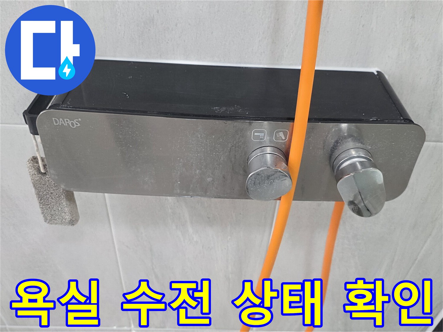 금속 재질의 욕실 수전과 타일 벽면 모습