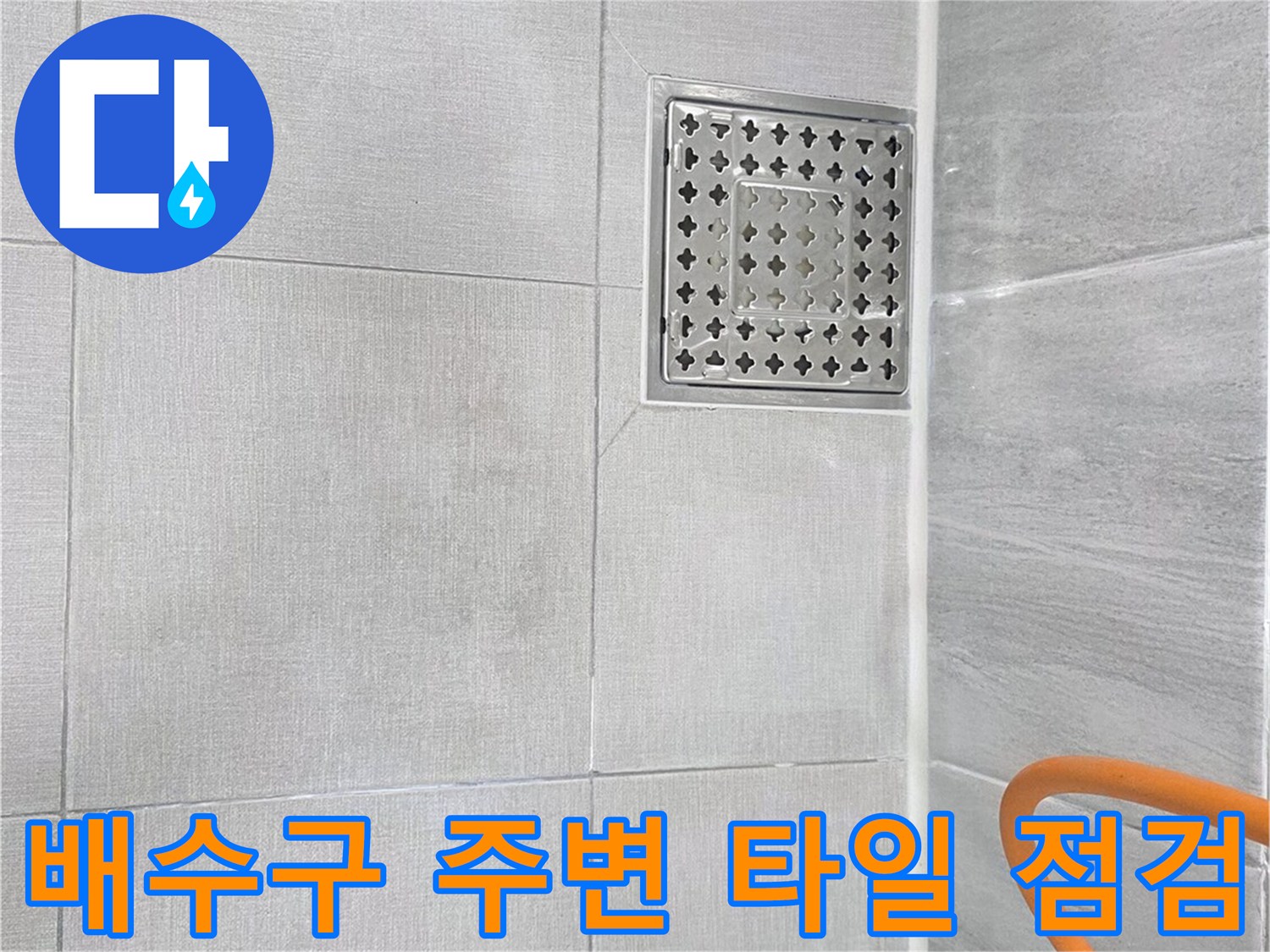 회색 욕실 바닥재와 금속 재질의 배수구 덮개