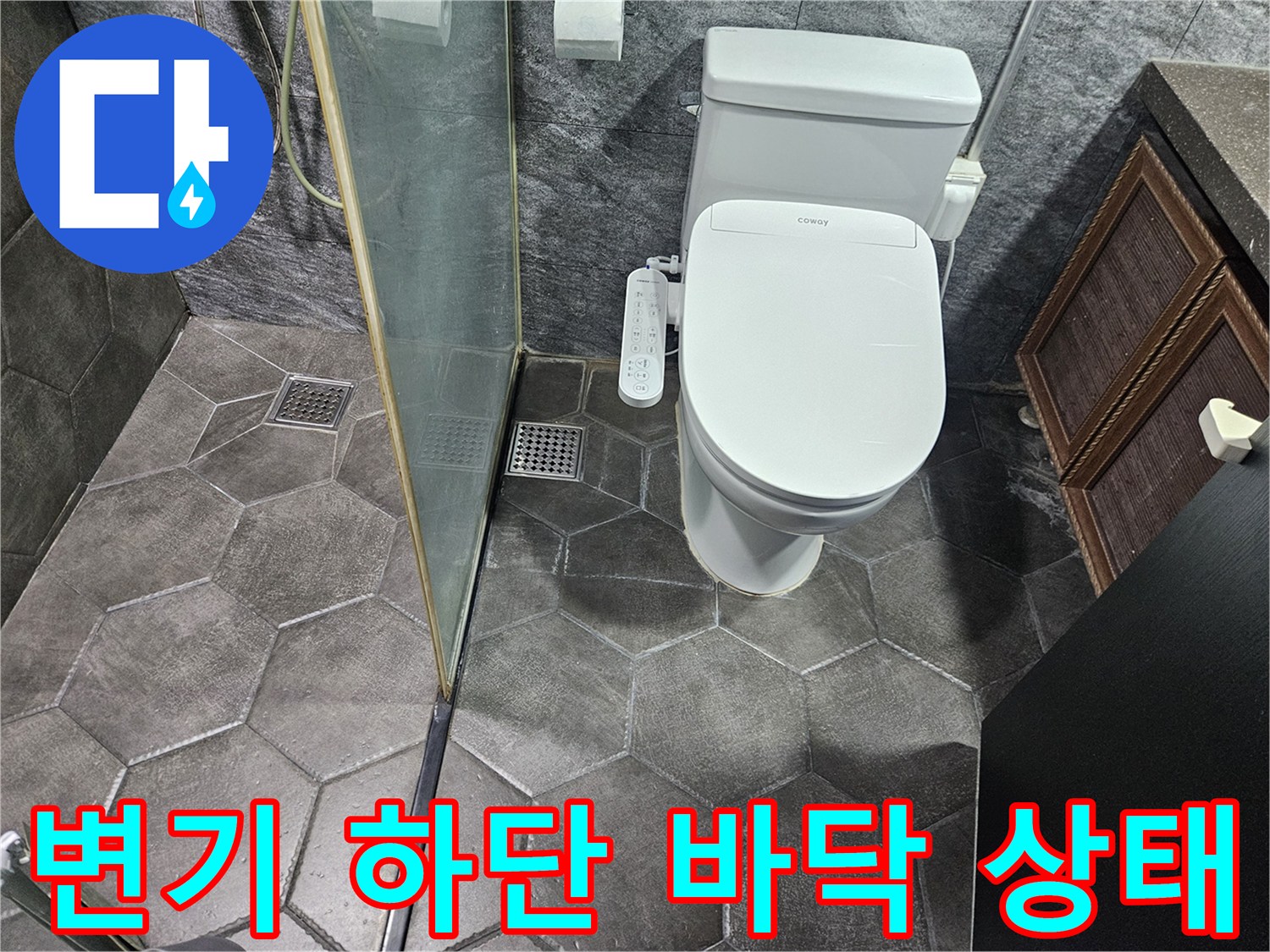 변기 뒤쪽 코너의 젖은 타일과 유리 파티션 경계선