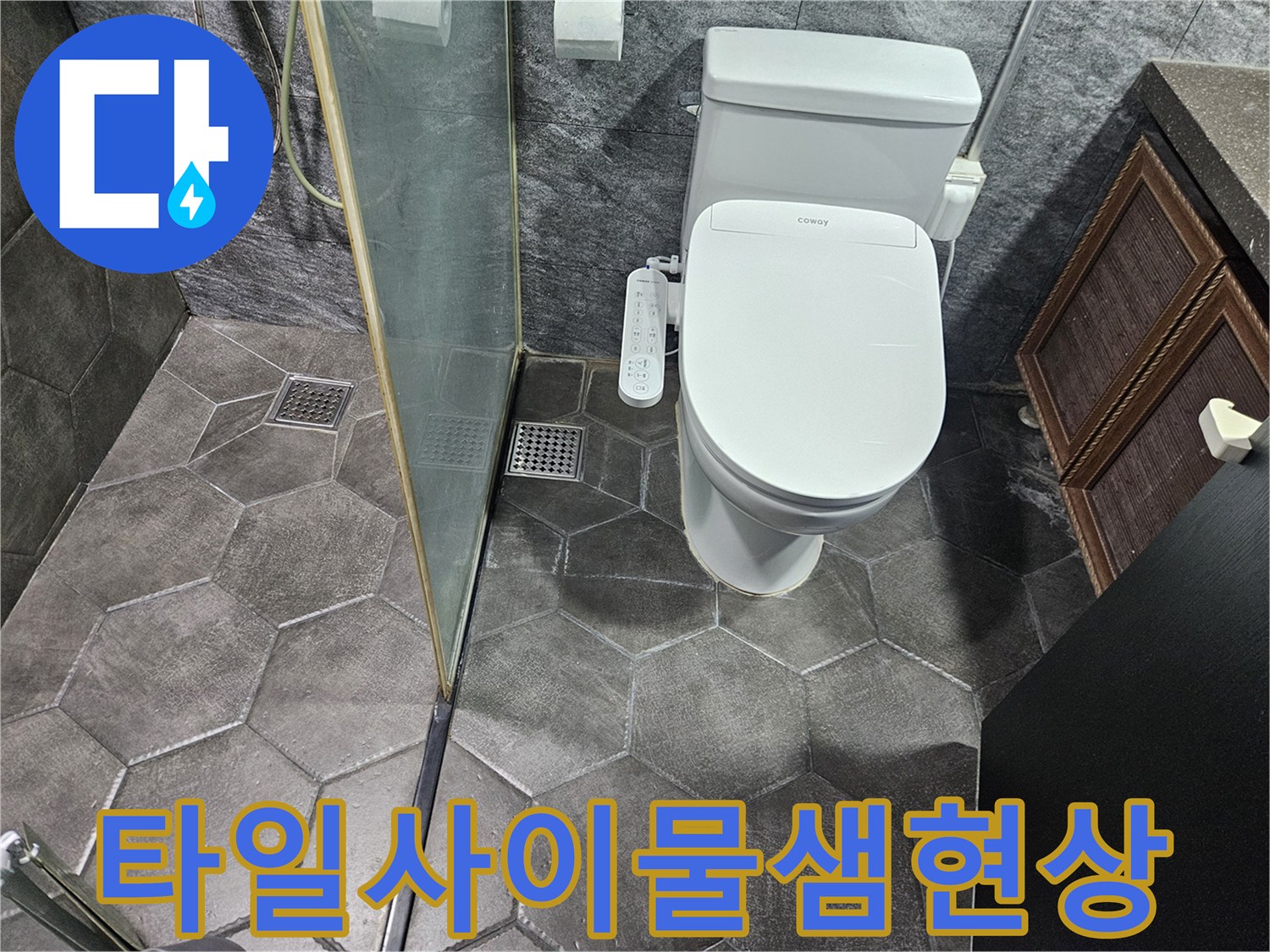 변기와 유리 파티션 사이 바닥 타일 근접샷