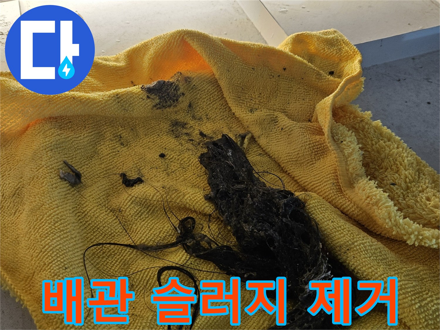 노란 타월 위에 쌓인 검게 변한 배수구 찌꺼기