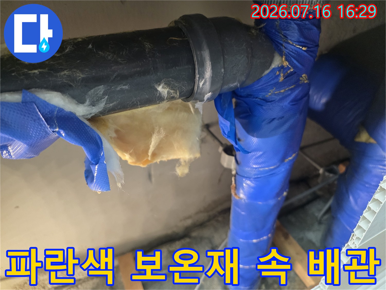 보온재를 걷어내고 노출된 배관의 연결 부위를 정밀하게 점검하는 모습