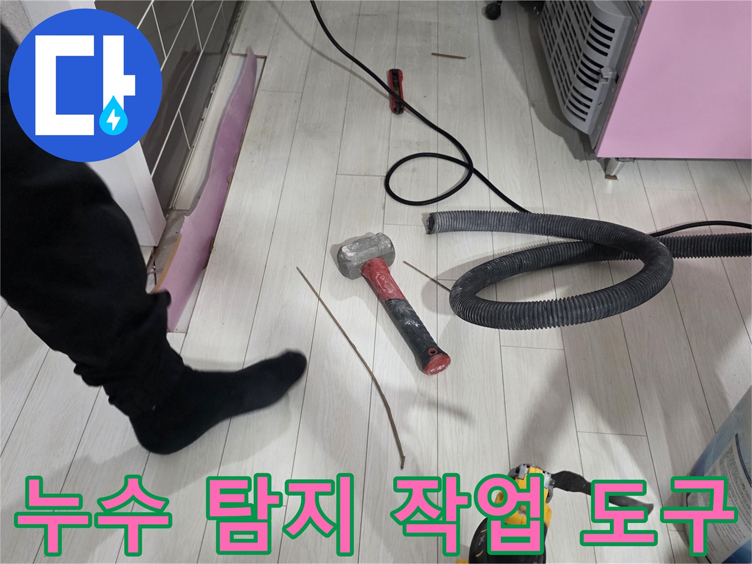 바닥 공사 현장의 망치와 청소기 호스