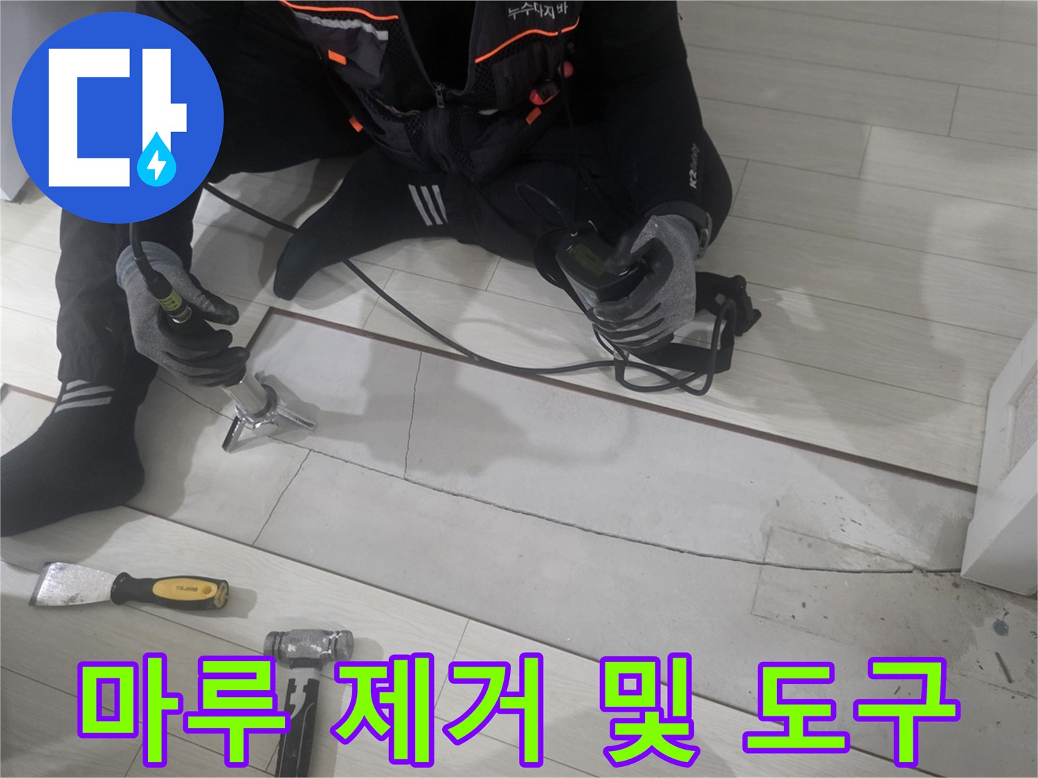 절개된 마루와 작업용 망치가 놓여 있습니다.