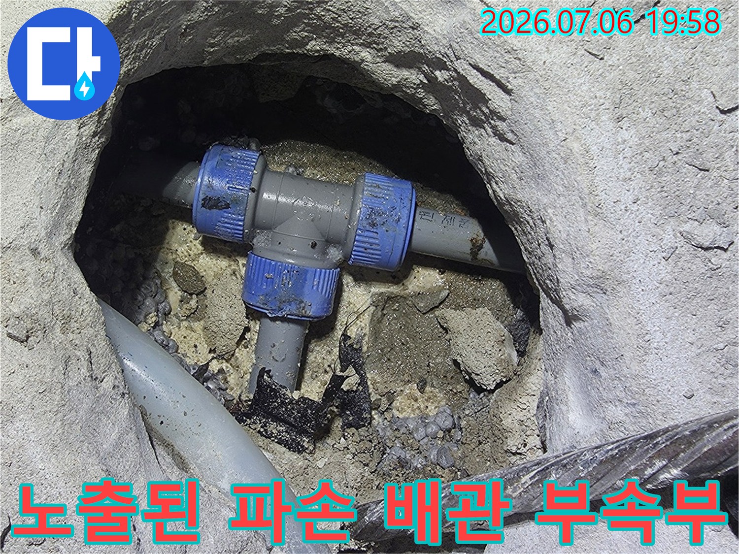 콘크리트 틈새에 노출된 파란색 연결 소켓과 배관