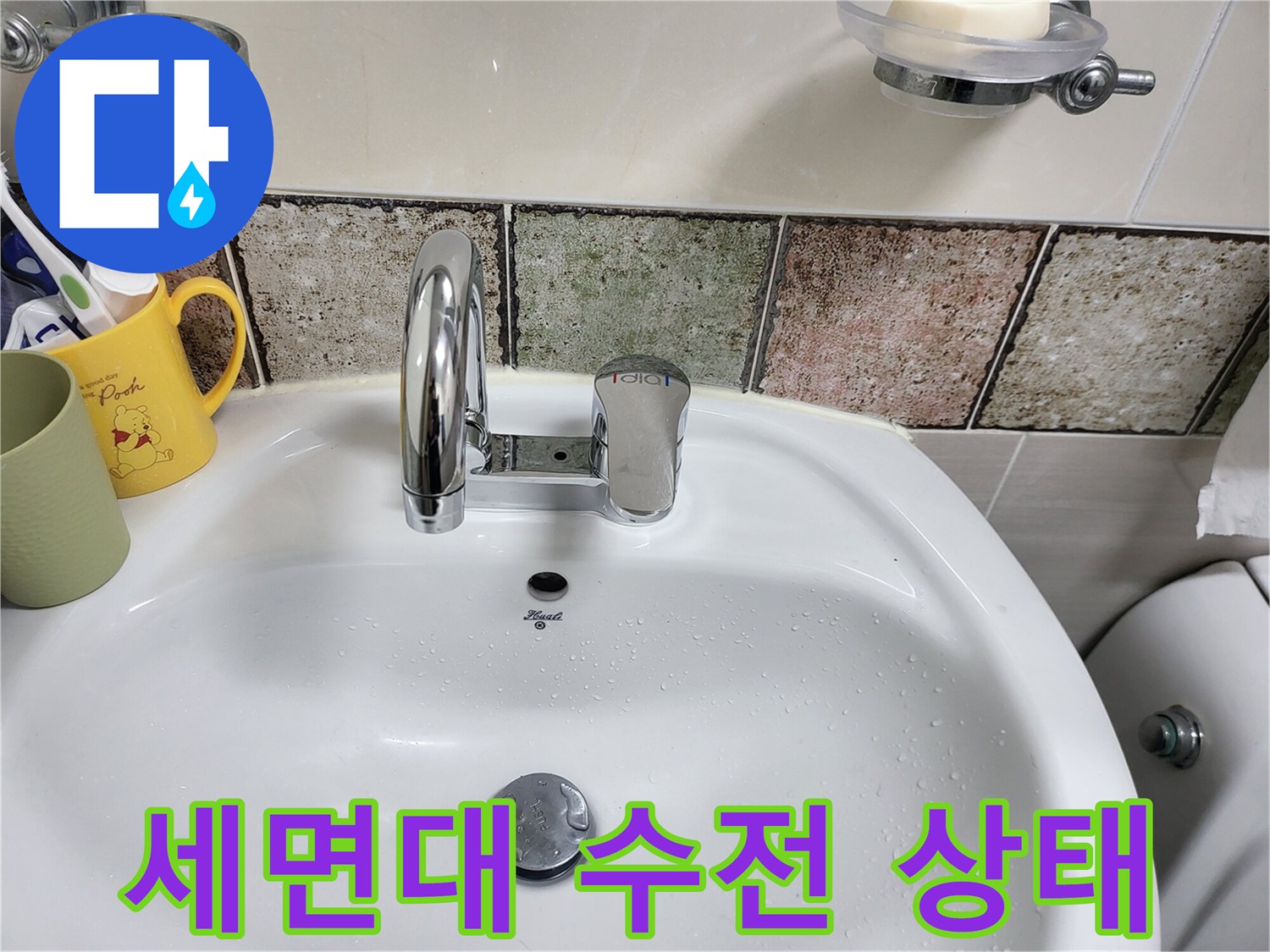 욕실 세면대 위쪽의 수전과 주변 타일 모습입니다.