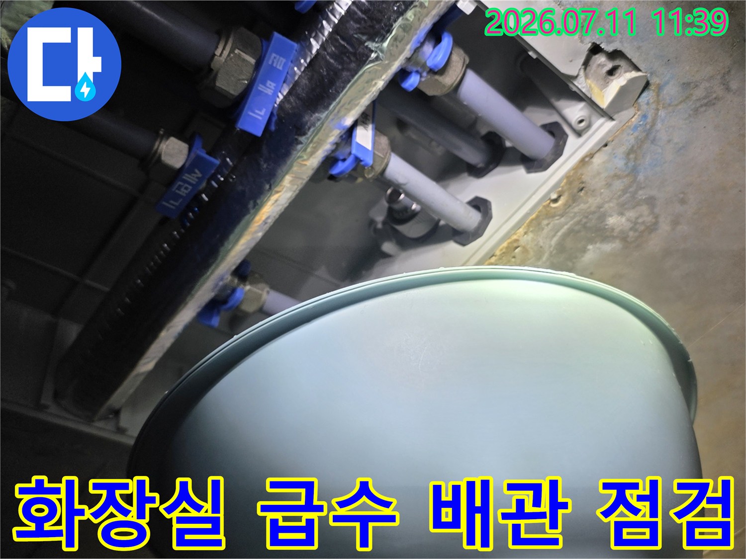 화장실 천장 내부의 파란색 배관 부속과 노출된 배관 점검 모습