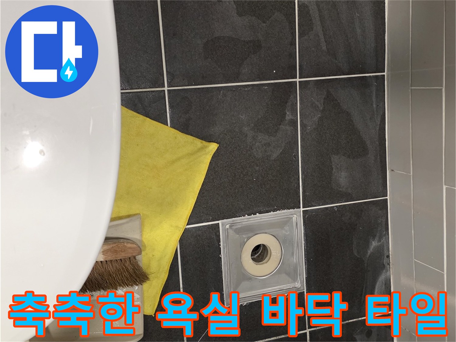 물기가 스며들어 어둡게 변한 배수구 주변 타일