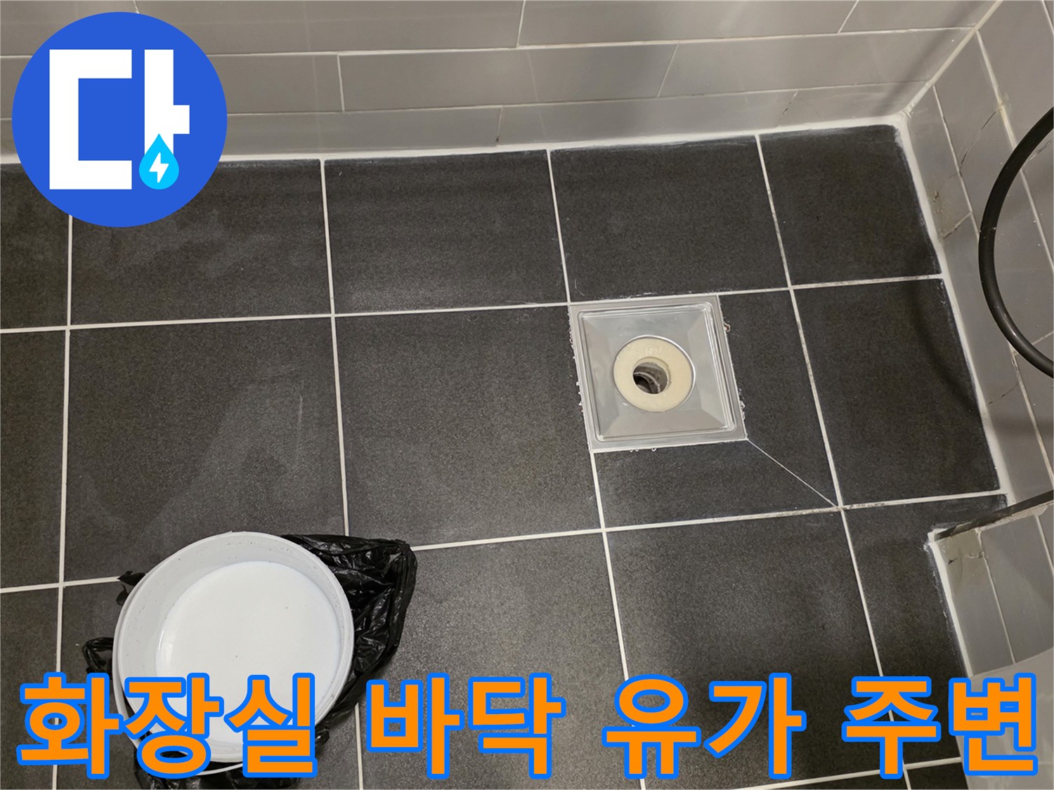 어두운 색 타일과 배수구 트랩의 연결 상태