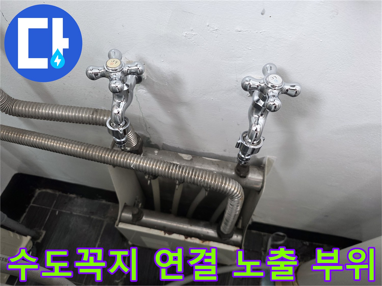벽면에 설치된 은색 자바라 호스와 수전 밸브