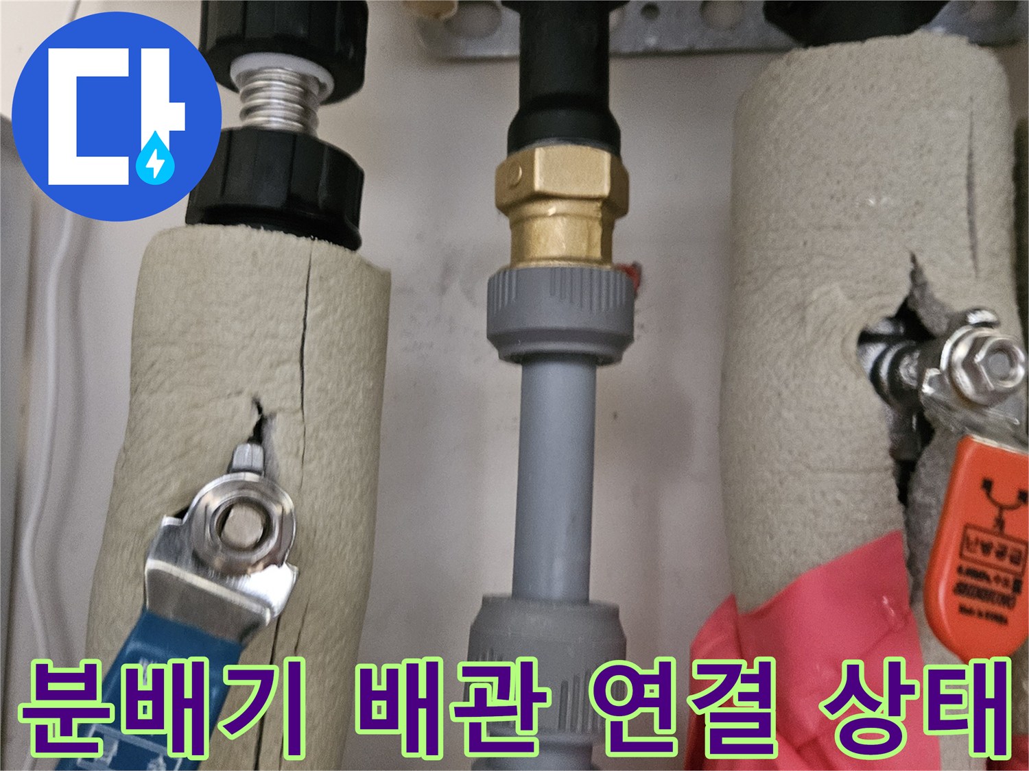 단열재가 씌워진 배관의 금속 부속과 연결 지점을 근접 촬영한 사진