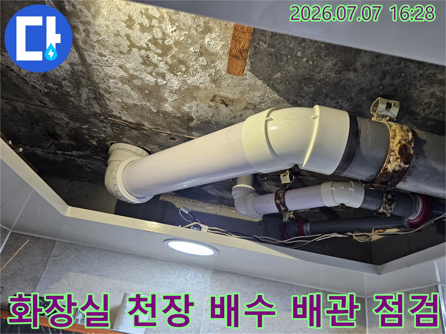 화장실 천장 내부의 노출된 배수 배관과 연결 부위 점검 모습