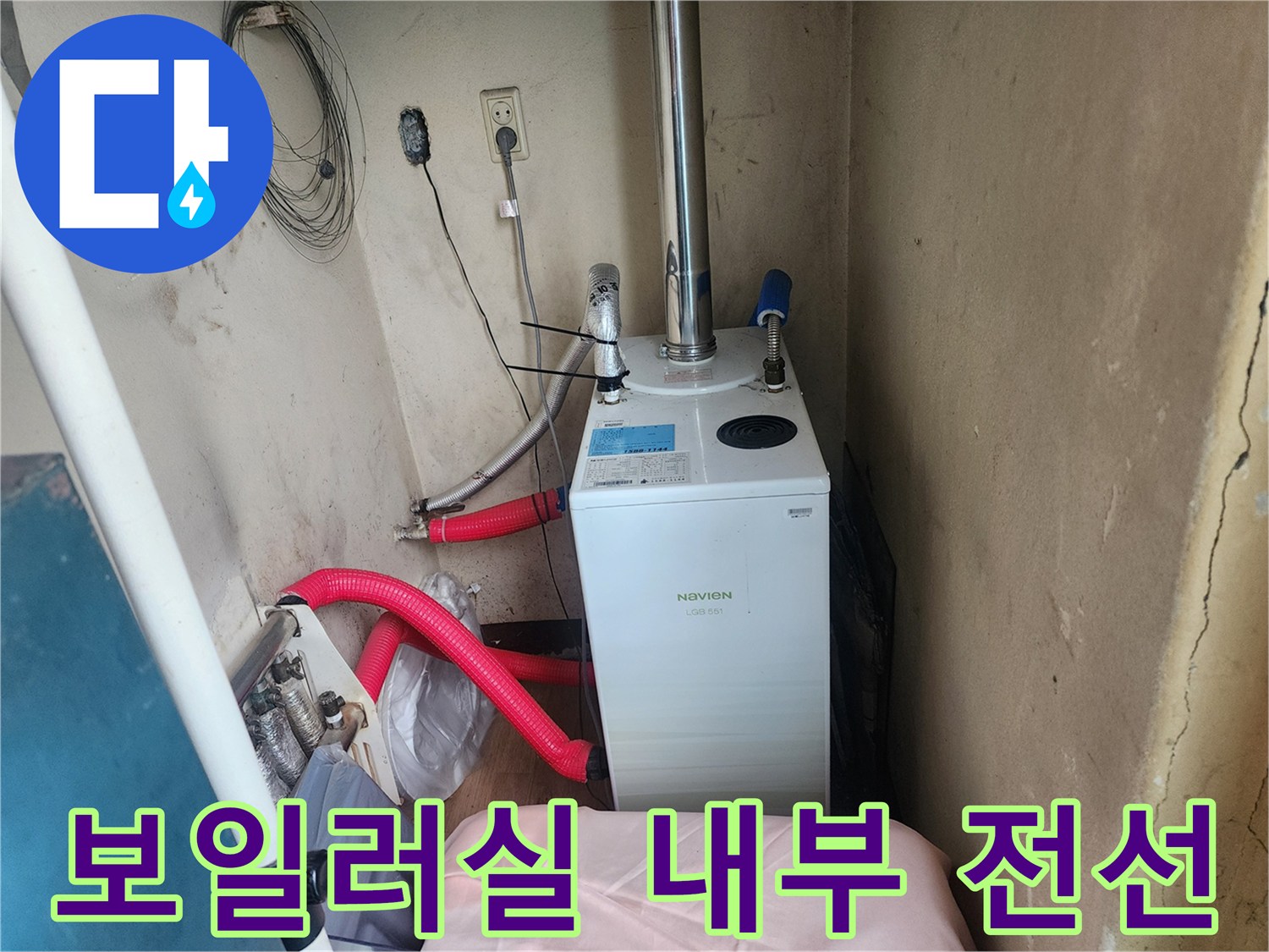 보일러 하단의 붉은색 호스와 벽면의 전기 콘센트 및 전선 모습
