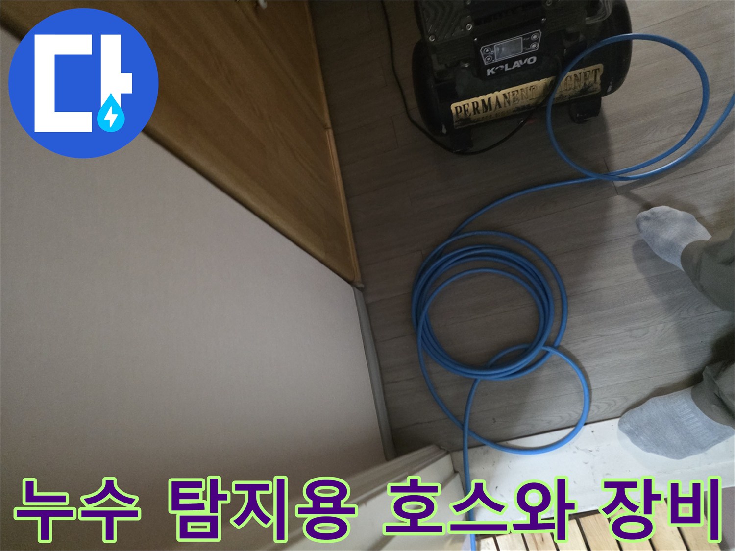 바닥에-설치된-누수-측정-장비와-파란색-호스