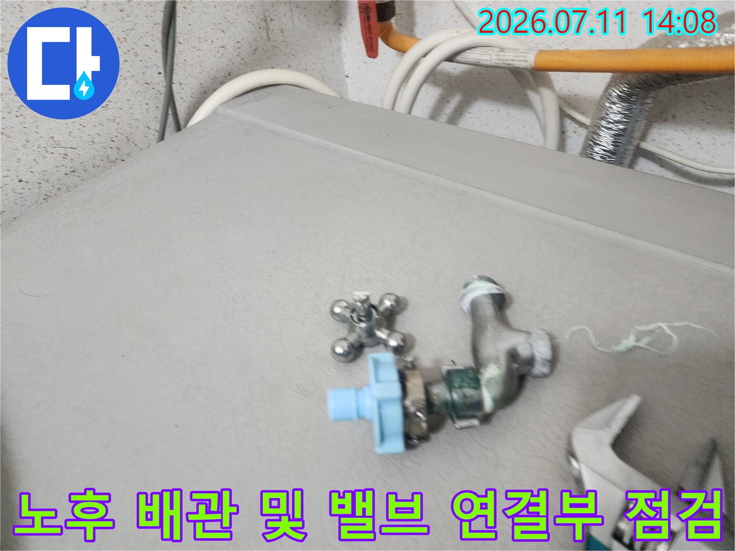 상부 기계 장치 위에 설치된 파란색 밸브와 배관 연결부 세부 확인