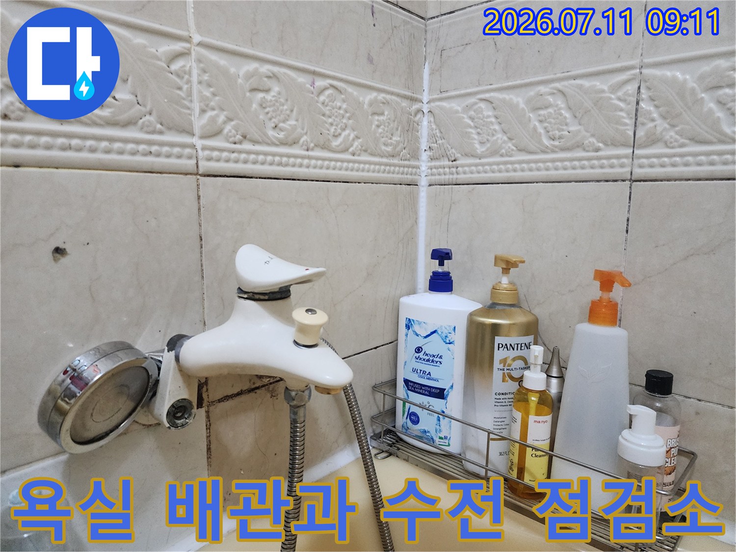 화장실 수전 주변에 위치한 배관 부위와 선반의 용품들